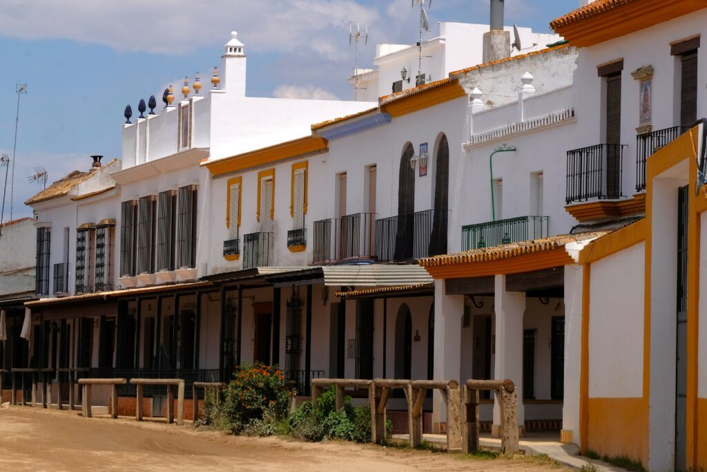 Vedere le facciate tipiche e le strade sabbiose di El Rocio